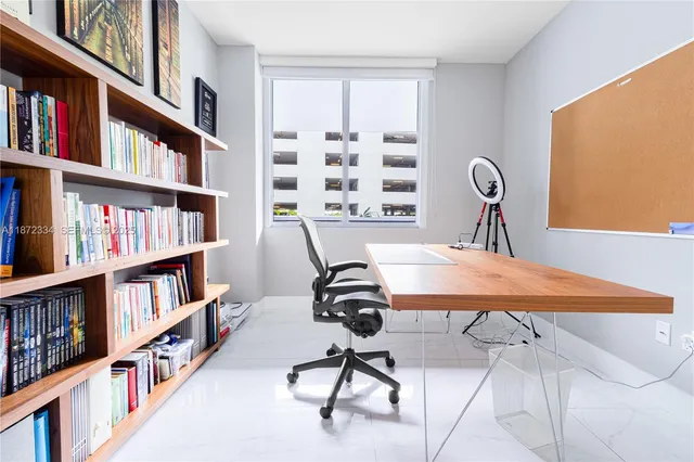 a view of a workspace with furniture and a book shelf