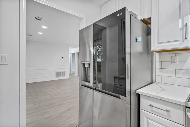 a kitchen with granite countertop white cabinets and stainless steel appliances
