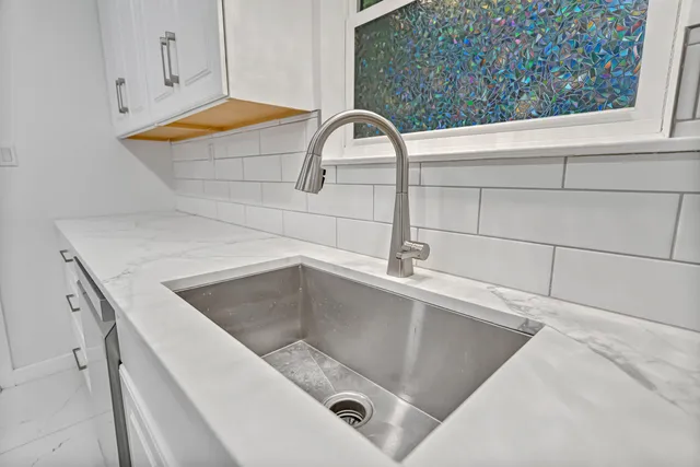 a kitchen with white cabinets and stainless steel appliances