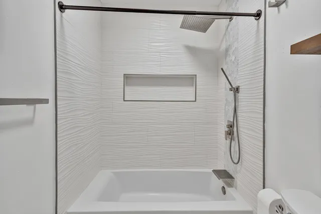 an empty room with wooden floor closet and windows