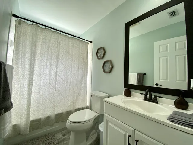 a bathroom with a sink a toilet and a mirror
