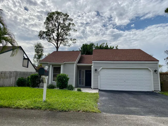 a front view of a house with a garden and garage