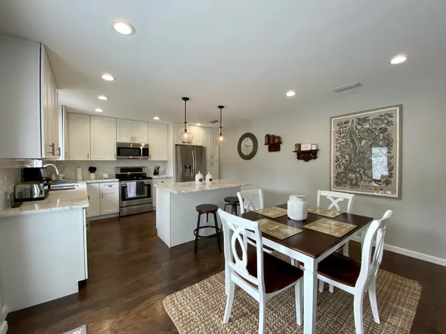 a kitchen with a dining table wooden cabinets and counter space