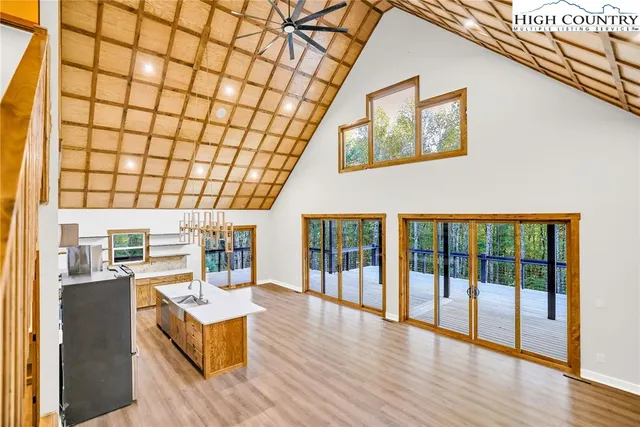 a living room with furniture floor to ceiling window and wooden floor