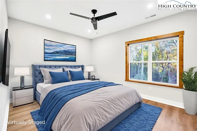 a bedroom with bed tv and window