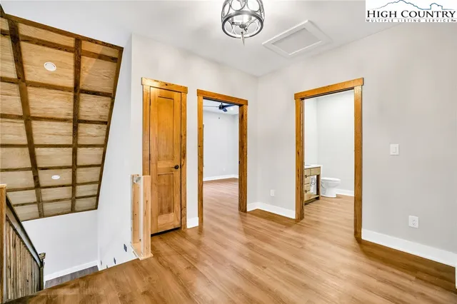 a view of a hallway with wooden floor and cabinet