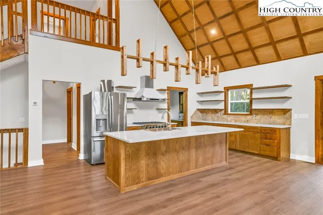 a large kitchen with stainless steel appliances granite countertop a large counter top and wooden floors