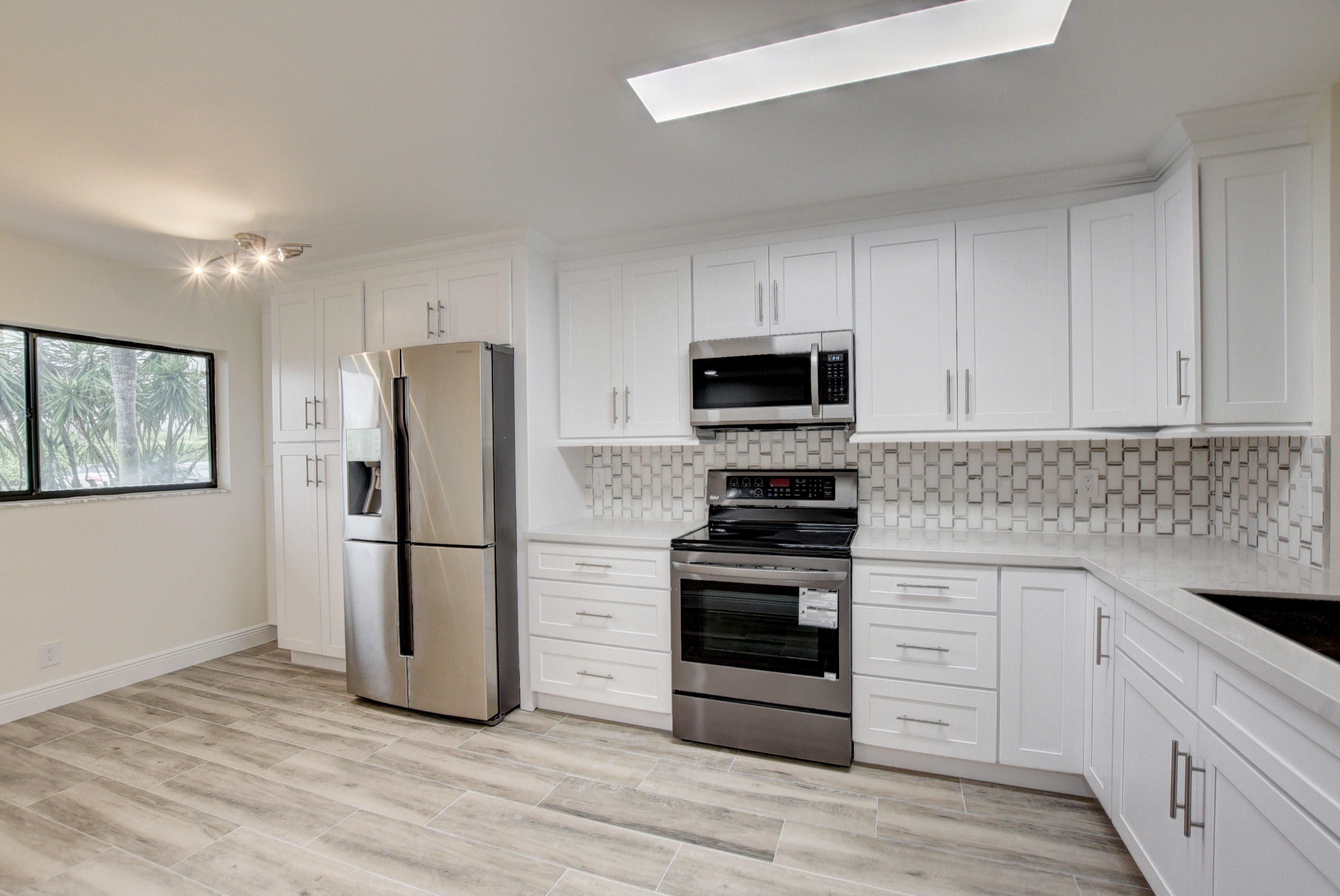 a kitchen with a refrigerator stove and white cabinets