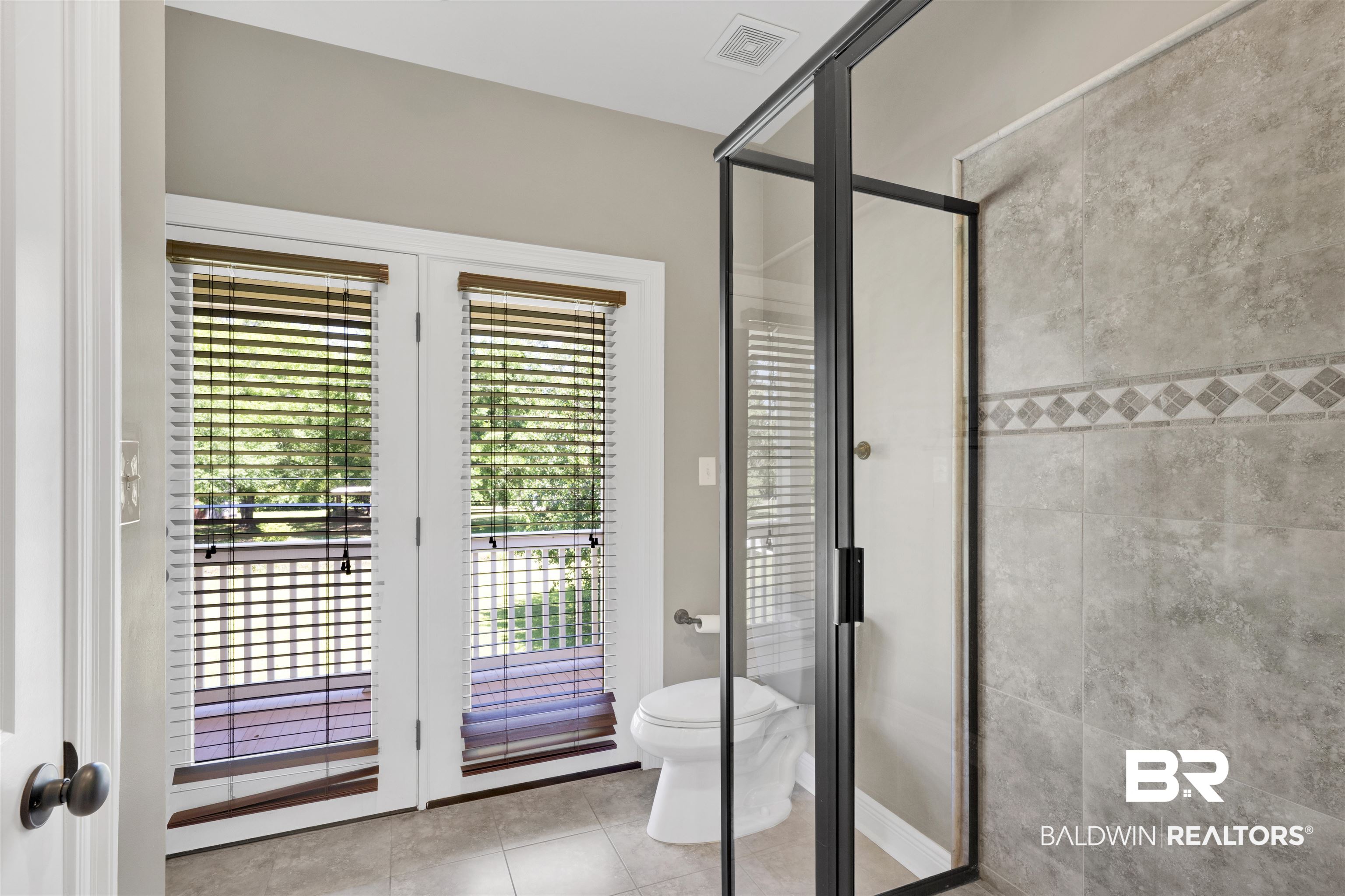 12944 Anna's Way Stapleton, AL 36578 - Photo 62 of 64 Framed glass shower enclosure with matte black trim and a tiled shower surround featuring a decorative mosaic accent band