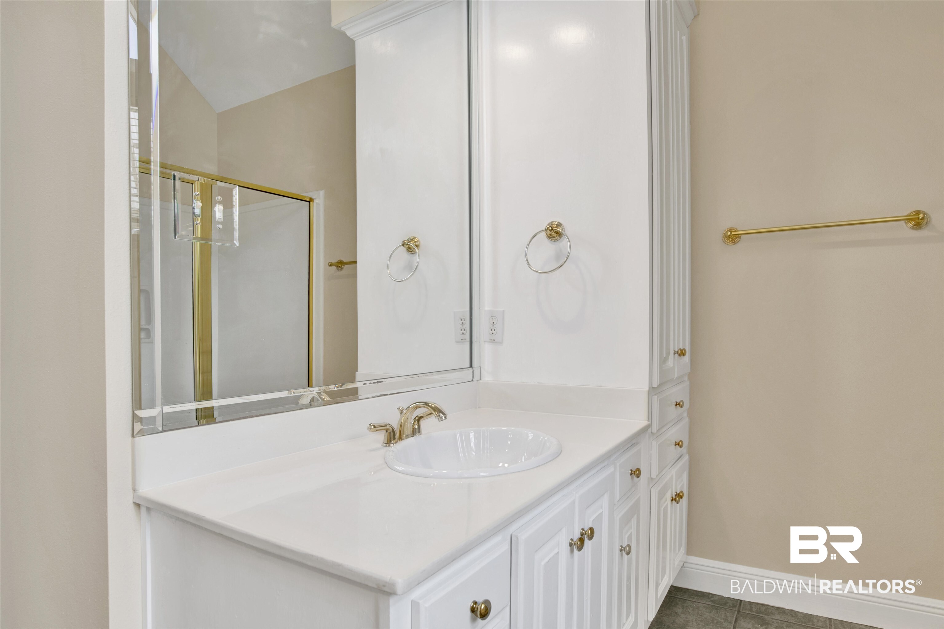 8847 Dawes Lake Road South Mobile, AL 36619 - Photo 22 of 47 White vanity with an integrated sink, polished brass fixtures, and a large framed mirror
