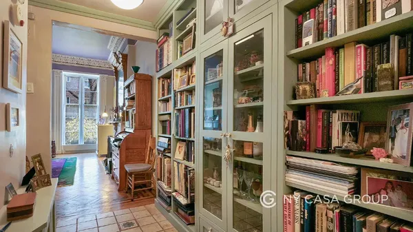 a living room with furniture a bookshelf and a large window