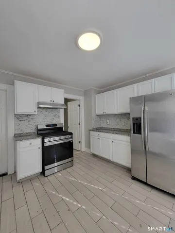 a kitchen with stainless steel appliances granite countertop a stove a sink and a refrigerator