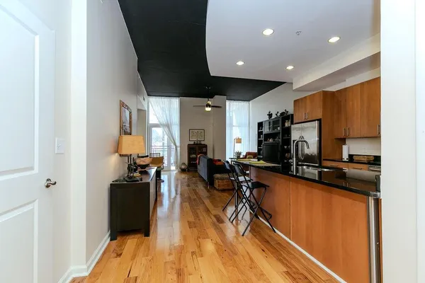 a view of a living room with kitchen view and a wooden floor