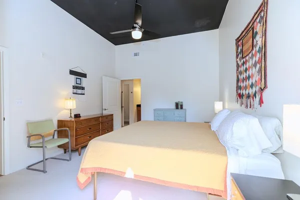a bedroom with a bed table and chair
