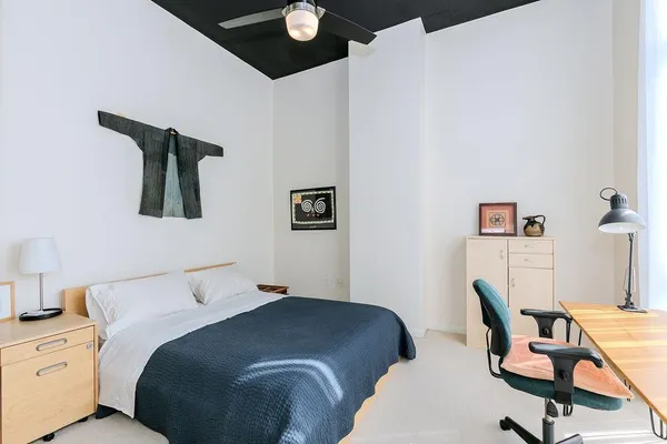 a bedroom with a bed chair and wall