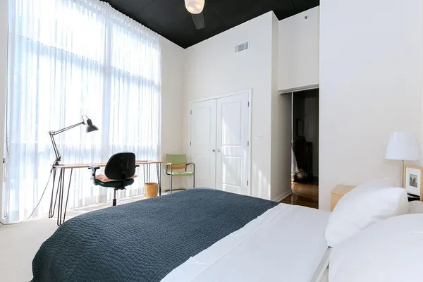 a bedroom with a bed and a large window