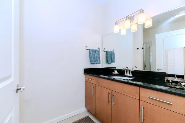 a bathroom with a granite countertop sink and a mirror