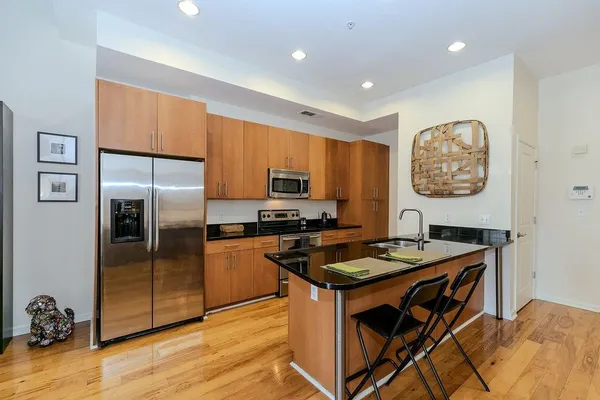 a kitchen with stainless steel appliances granite countertop a stove a sink a refrigerator and a refrigerator