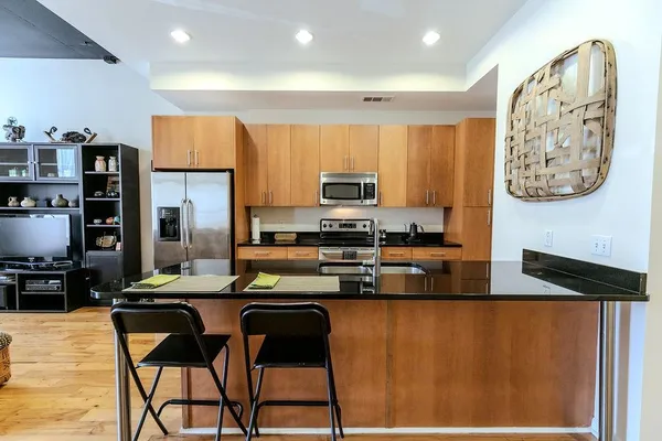 a kitchen with stainless steel appliances granite countertop a refrigerator and a stove top oven