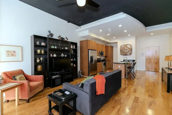 a living room with furniture a flat screen tv and a rug