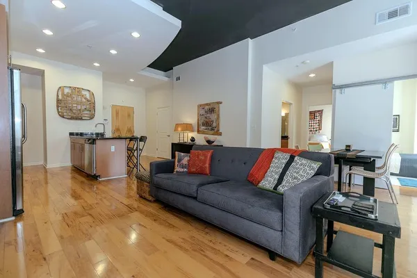 a living room with furniture and a wooden floor