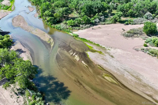 an aerial view of a house with a yard and a lot of flower plants