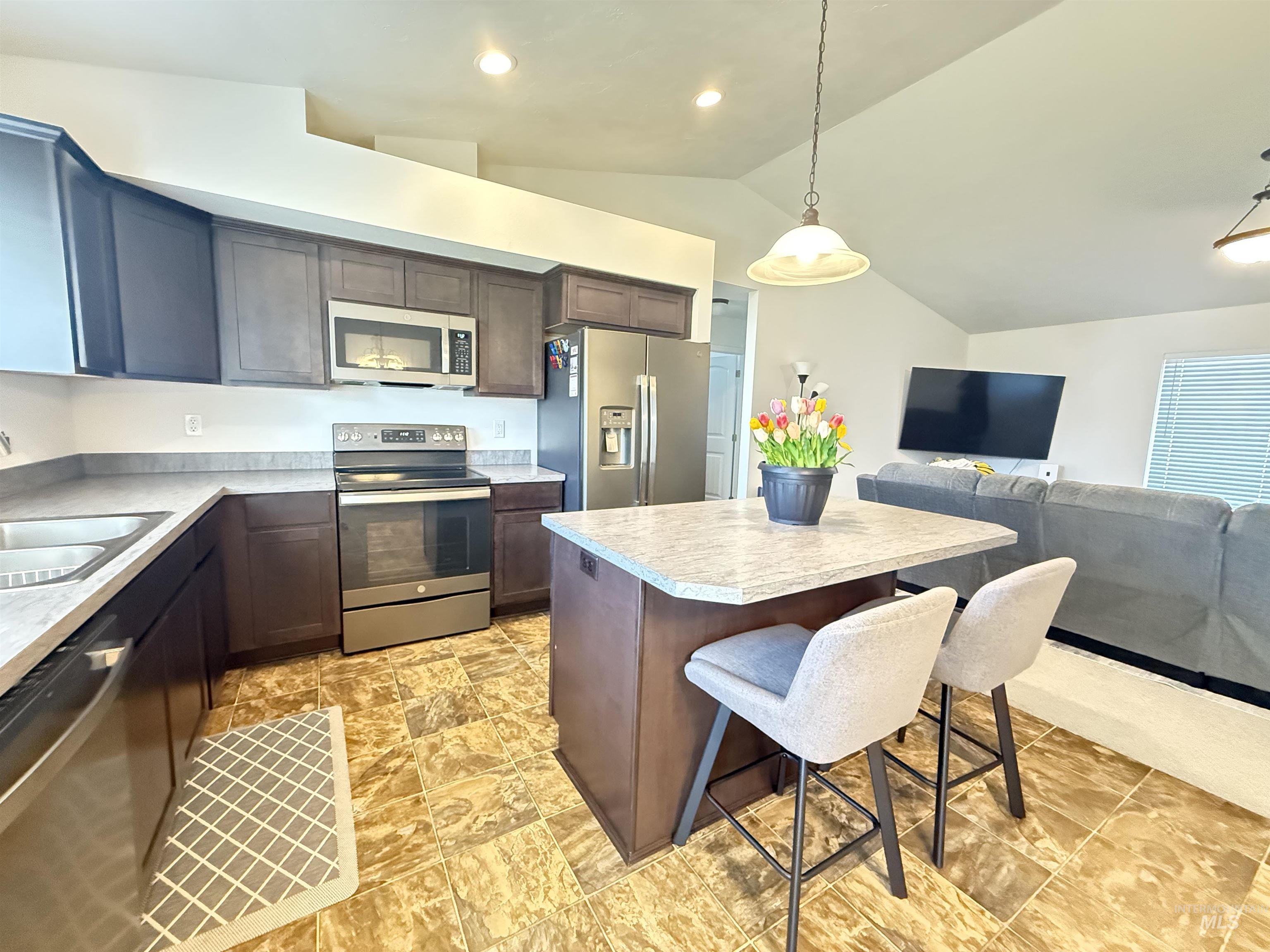 1556 Frontier Drive Lewiston, ID 83501 - Photo 6 of 23 Modern kitchen featuring wood-finish cabinetry, stainless steel appliances, and light-toned countertops