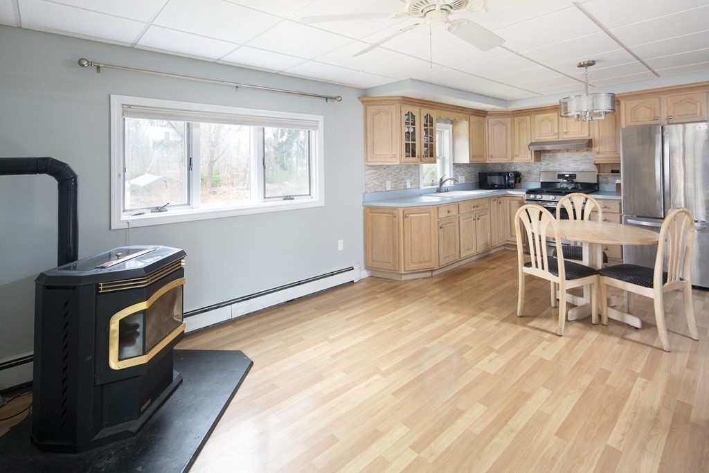 39 Shufelt Road Walpole, MA 02071 - Photo 19 of 33 a kitchen with stainless steel appliances granite countertop a stove a sink a refrigerator white cabinets with wooden floor dining table and chairs