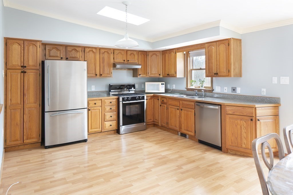 39 Shufelt Road Walpole, MA 02071 - Photo 4 of 33 a kitchen with stainless steel appliances granite countertop a stove a sink dishwasher a refrigerator and a microwave with wooden floor