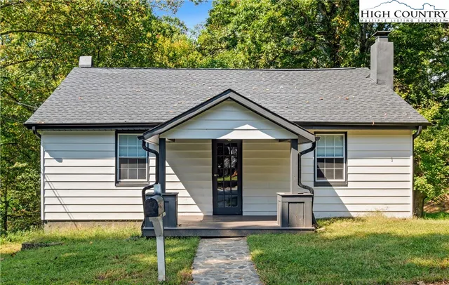 a house view with a garden and large trees