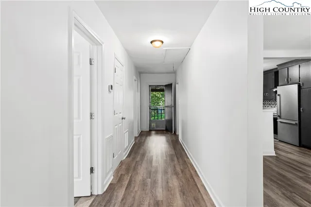 a view of a hallway with wooden floor and staircase
