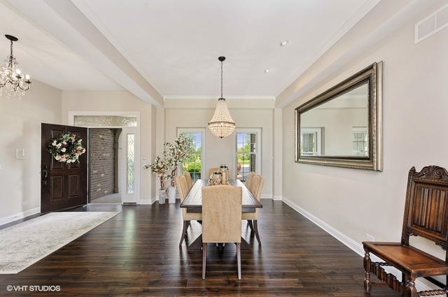 7313 Lone Oak Road Spring Grove, IL 60081 - Photo 3 of 29 a dining room with wooden floor a chandelier a wooden table and chairs