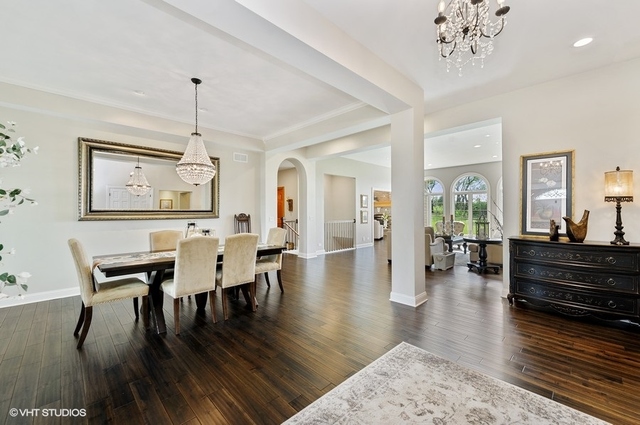 7313 Lone Oak Road Spring Grove, IL 60081 - Photo 4 of 29 a view of a dining room and livingroom with furniture wooden floor a chandelier