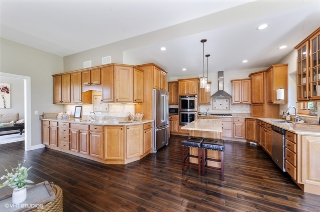 7313 Lone Oak Road Spring Grove, IL 60081 - Photo 7 of 29 a kitchen with stainless steel appliances wooden floors wooden cabinets and a window