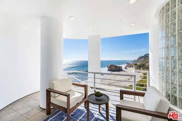 a dining room with furniture a chandelier and wooden floor