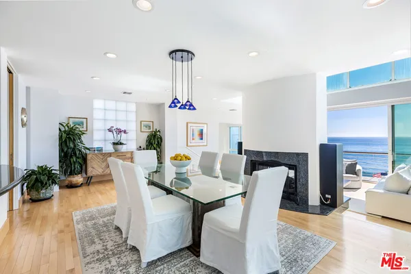 a kitchen with stainless steel appliances kitchen island granite countertop a stove a sink and white cabinets with wooden floor