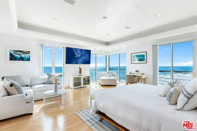 a bedroom with furniture and a large window