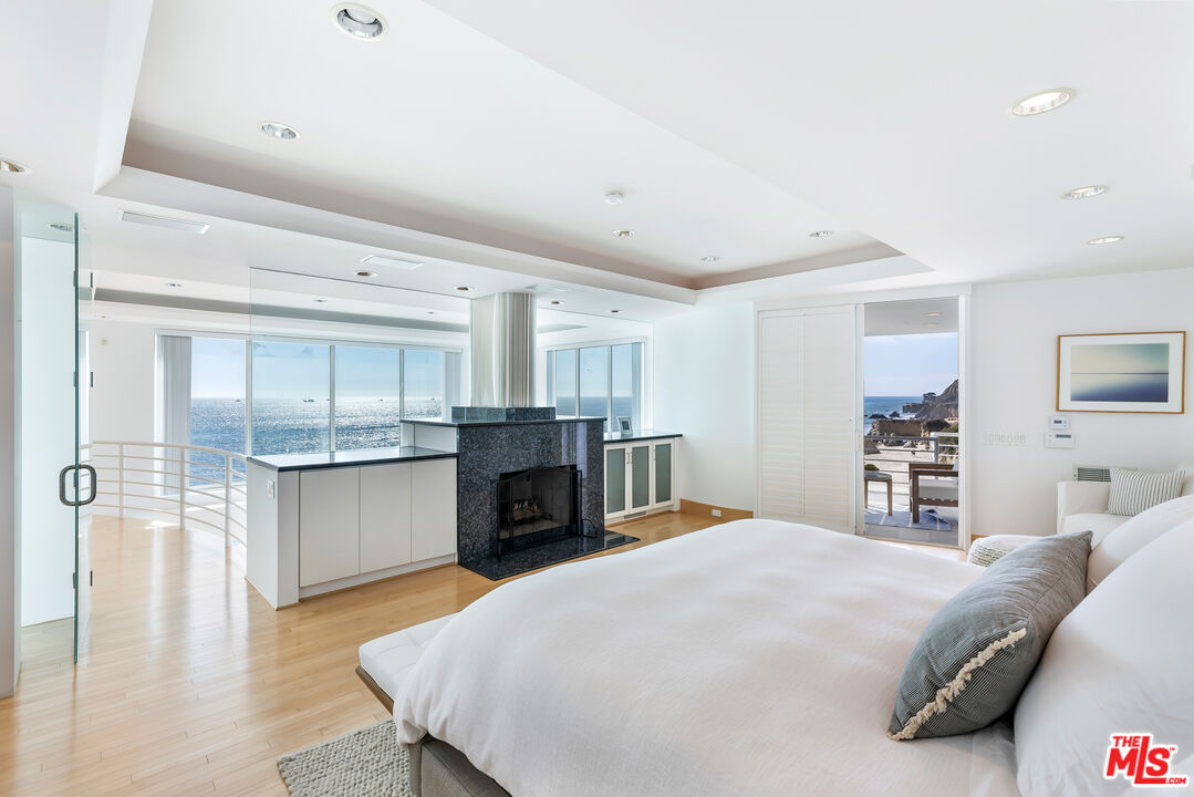 32062 Pacific Coast Highway Malibu, CA 90265 - Photo 10 of 31 a spacious bedroom with a large bed and a fireplace