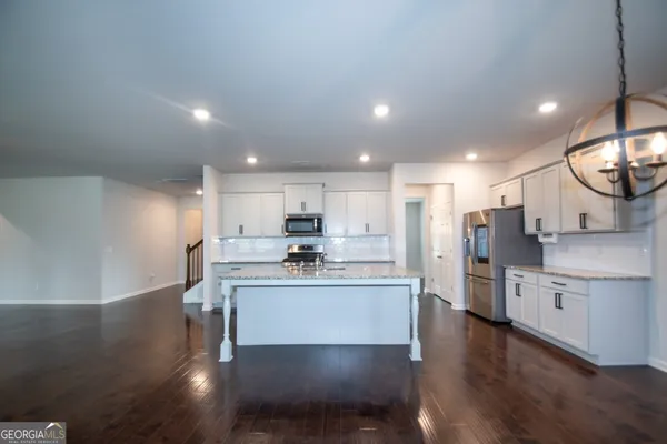 a kitchen with stainless steel appliances kitchen island hardwood floor sink and stove