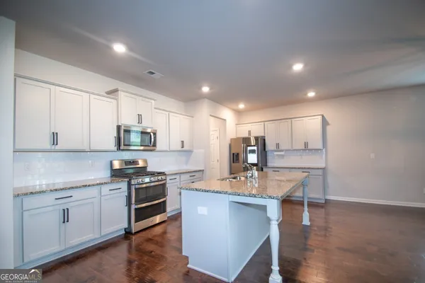 a kitchen with a sink stainless steel appliances and white cabinets