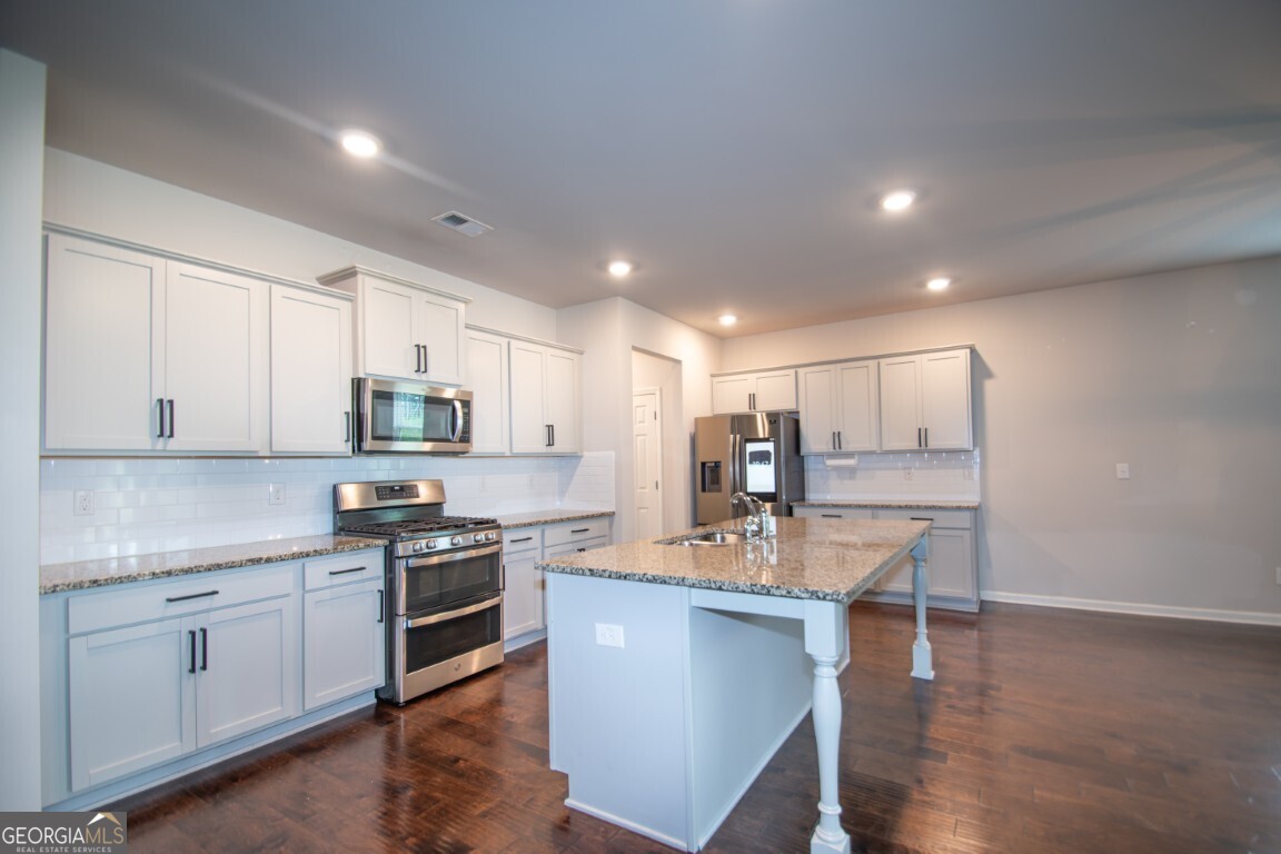 8084 Louis Drive Locust Grove, GA 30248 - Photo 12 of 33 a kitchen with a sink stainless steel appliances and white cabinets
