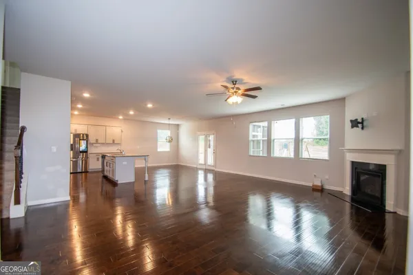 a view of empty room with wooden floor and fireplace