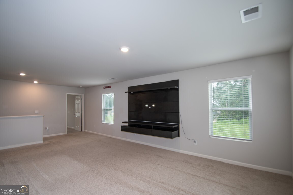 8084 Louis Drive Locust Grove, GA 30248 - Photo 15 of 33 a view of an empty room with a fireplace and a window