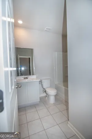 a spacious bathroom with a toilet sink and mirror
