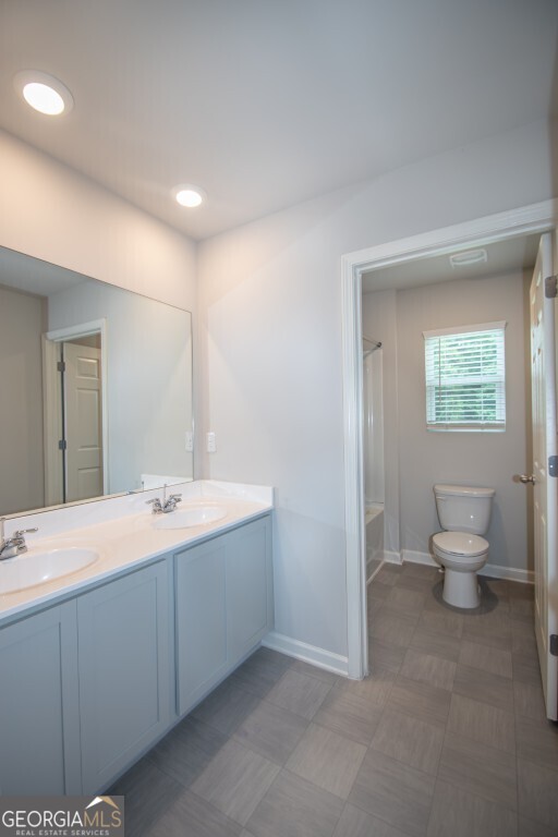 8084 Louis Drive Locust Grove, GA 30248 - Photo 20 of 33 a spacious bathroom with a toilet sink and mirror