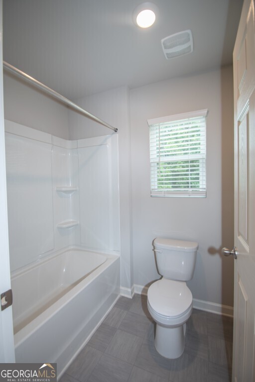 8084 Louis Drive Locust Grove, GA 30248 - Photo 21 of 33 a bathroom with a toilet and a bathtub