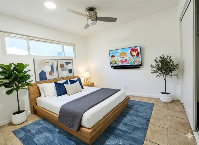 a spacious bedroom with a large bed and a potted plant