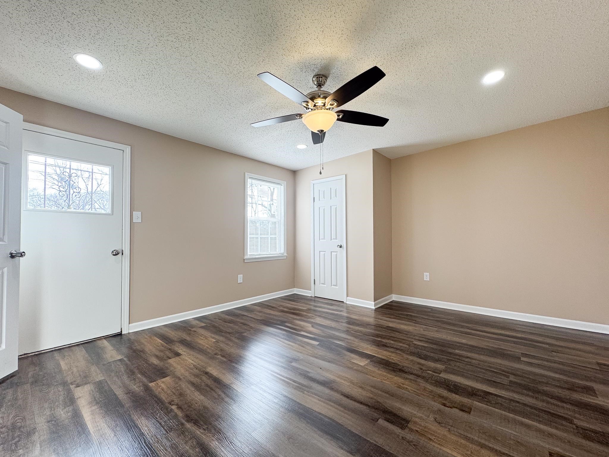 842 Rock Road Memphis, TN 38122 - Photo 14 of 26 Empty room with a textured ceiling, baseboards, dark wood-type flooring, and ceiling fan