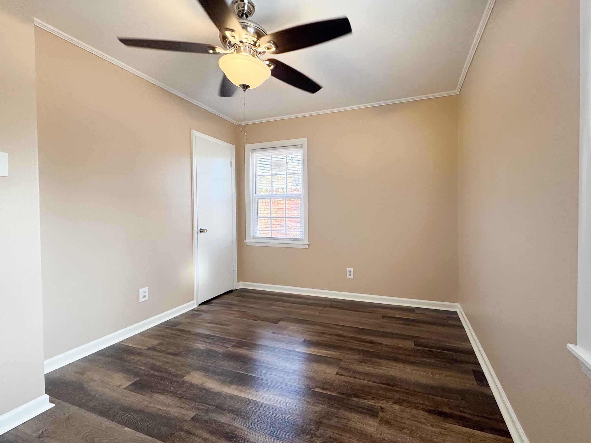 842 Rock Road Memphis, TN 38122 - Photo 17 of 26 Spare room with ceiling fan, baseboards, dark wood finished floors, and crown molding