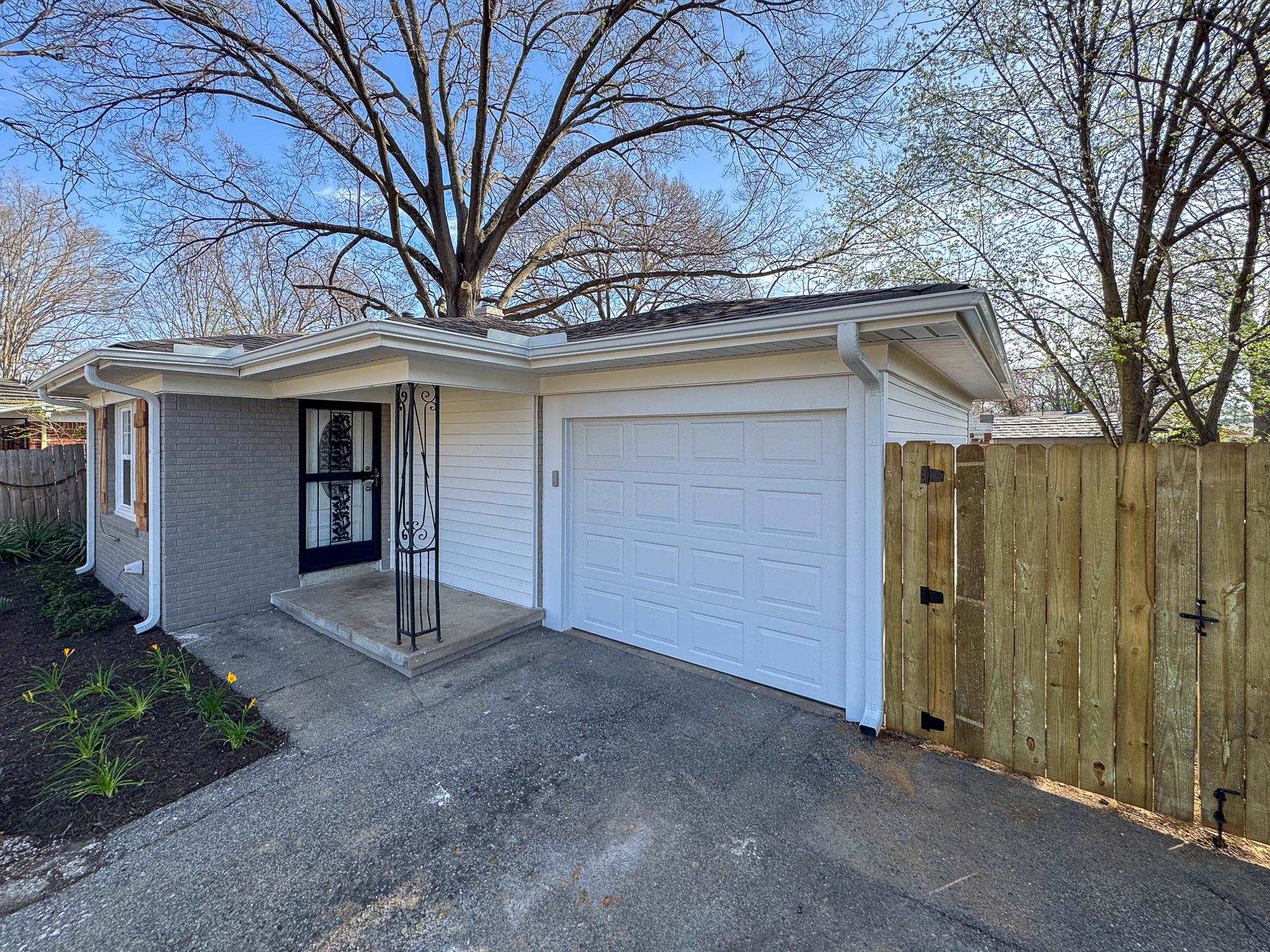 842 Rock Road Memphis, TN 38122 - Photo 3 of 26 View of front facade with a garage, brick siding, and fence